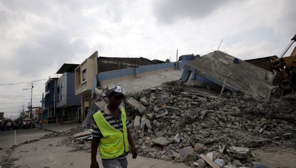 A worker walks past a collapsed building after an earthquake struck off the Pacific coast, in Guayaquil, Ecuador, April 17, 2016.