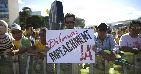 Protesters support the impeachment of Rousseff with a sign reading, 
