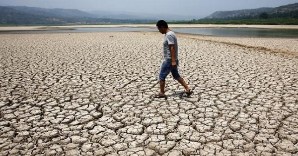 A man walks through the dried-up bed of a reservoir in Sanyuan county, Shaanxi province, July 30, 2014.