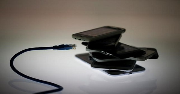 An illustration picture shows a network cable next to a pack of smartphones in Berlin, June 7, 2013.