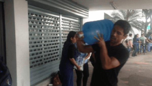 Matias Oyola, midfielder for the Barcelona Sporting Club, delivers water to the stadium, where the team is collecting donations.