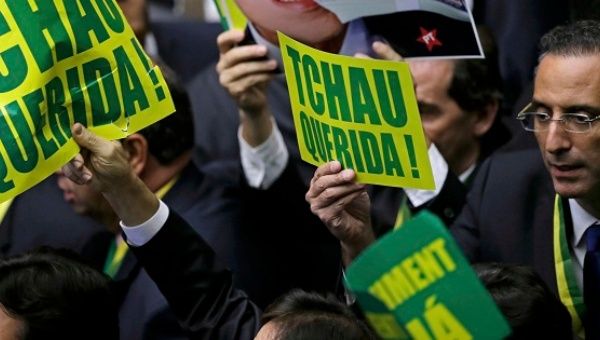 Members of Brazil's lower house in favor of the impeachment of President Dilma Rousseff hold up signs reading 