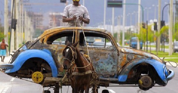 A Brazilian man transports on his horse-drawn cart the remains of a Volkswagen Beetle that caught fire and was abandoned by its owner.