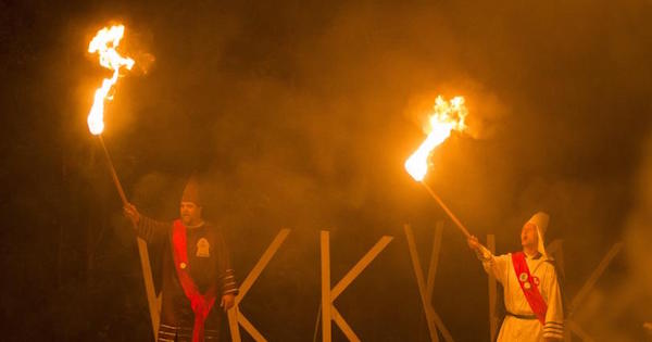 Members of the Rebel Brigade Knights and the Nordic Order Knights, groups that both claim affiliation with the Ku Klux Klan, hold their lit torches during a cross-lighting ceremony at a private residence in Henry County, Virginia, Oct. 11, 2014