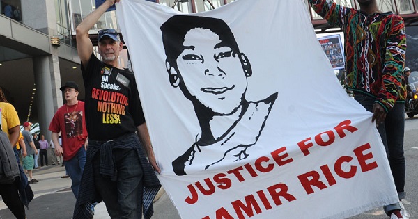 Protesters hold a banner demanding justice for Tamir Rice, gunned down by a white police officer in November, 2014.