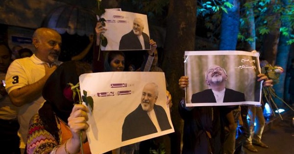 Iranians hold pictures of Iranian Foreign Minister Mohammad Javad Zarif as they celebrate in the street following a nuclear deal with major powers, in Tehran July 14, 2015.
