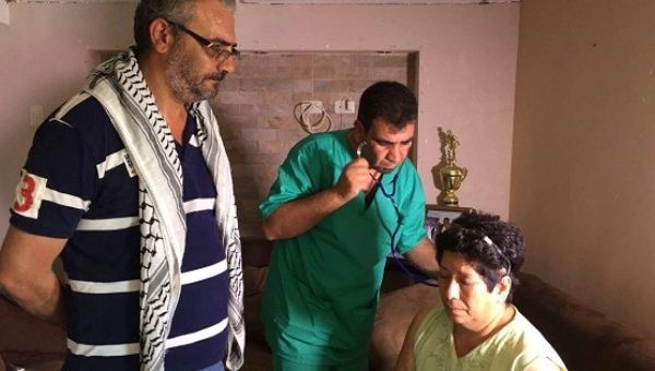 A doctor with the Palestinian medical team in Ecuador examines a woman affected by the earthquake that took place at the coastal region last week, April 25, 2016.