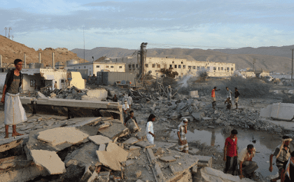 People inspect damage at a site hit by Saudi-led air strikes in the al Qaeda-held port of Mukalla city in southern Yemen April 24, 2016
