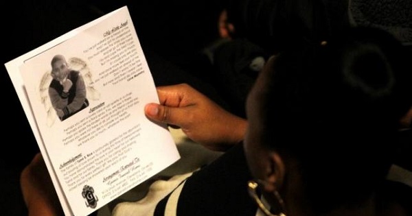 A mourner reads the obituary from the program during the funeral service for Tamir Rice in Cleveland, Ohio Dec. 3, 2014.