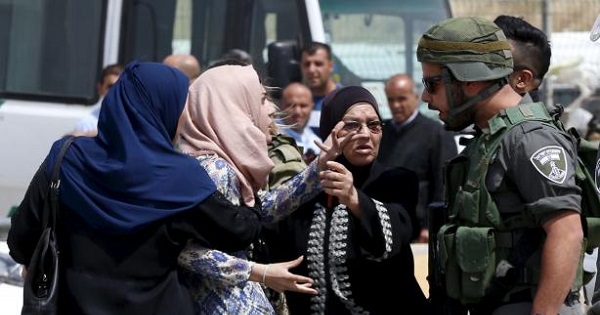 A Palestinian woman argues with an Israeli policeman near the scene of the shooting by Israeli police near Qalandia checkpoint, April 27, 2016.