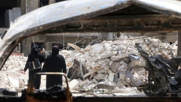 Women walk past damage near the Doctors without Borders-backed al-Quds hospital after it was hit by airstrikes, in a rebel-held area of Syria's Aleppo, April 28, 2016. 