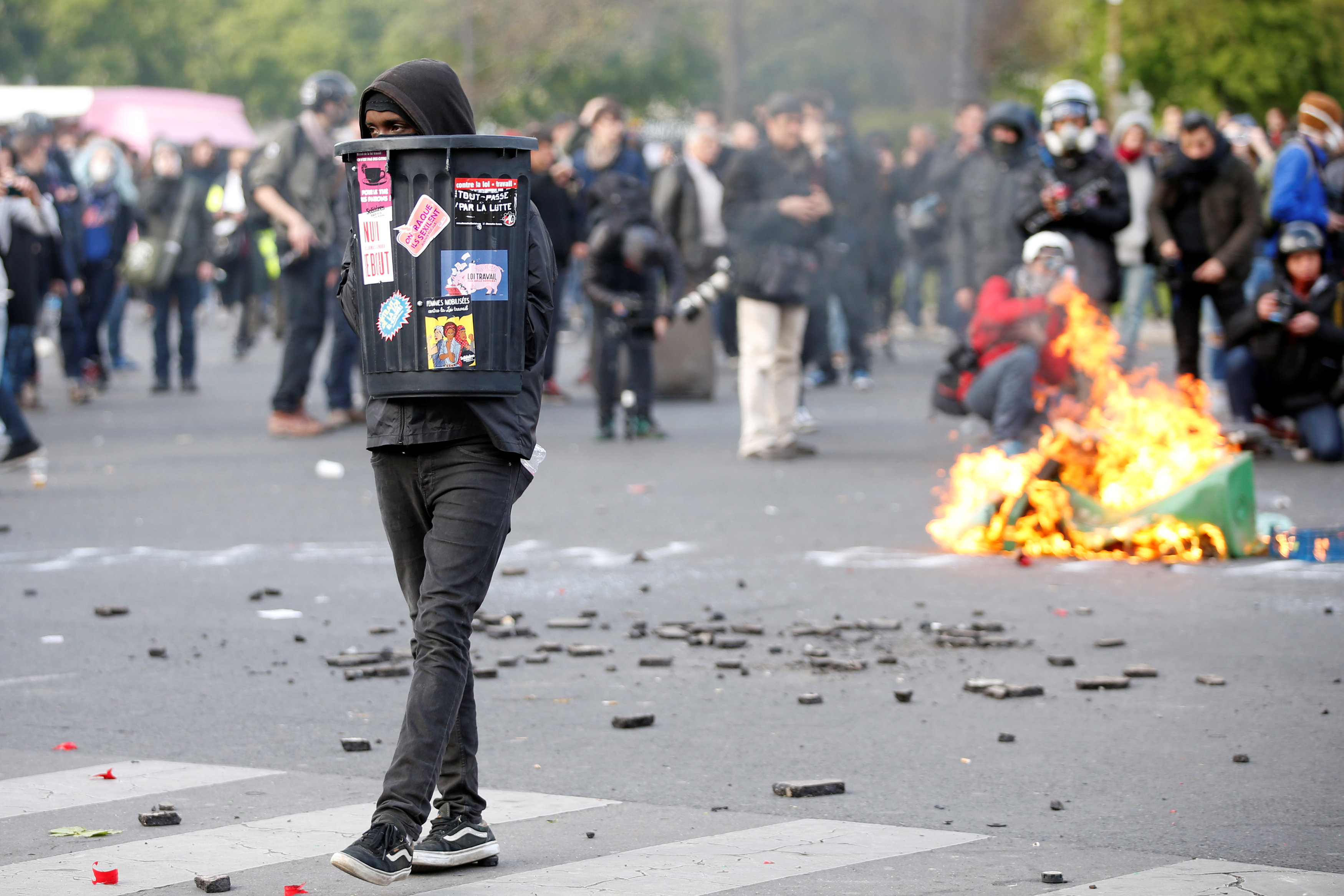 Masked youths face off with French police during a demonstration against the French labour law proposal in Paris, France, as part of a nationwide labor reform protests and strikes, April 28, 2016.