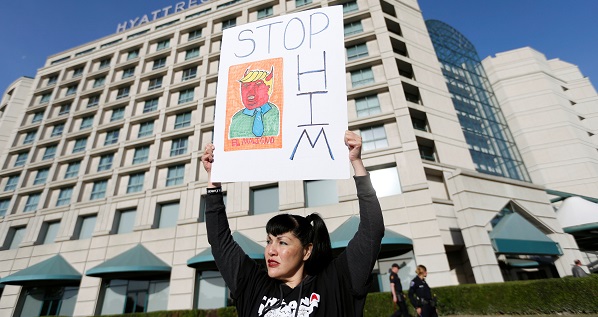 A demonstrator holds a sign in protest of Republican U.S. presidential candidate Donald Trump during the California Republican Convention in Burlingame, California.