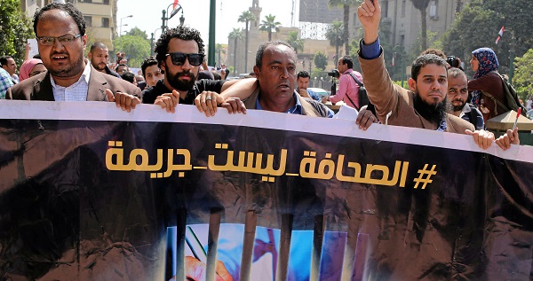 Egyptian journalists hold a banner outside the Egyptian Press Syndicate in downtown Cairo during a protest against the interior minister.