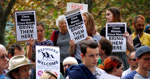 The Refugee Action Coalition holds placards demanding the closing of refugee detention centers during a demonstration.