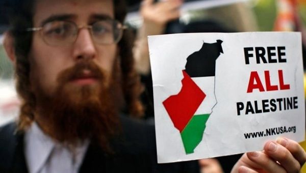 A Jewish man holds a sign during a protest against the Israeli government.