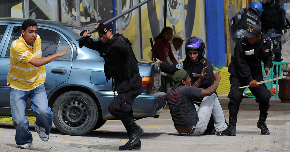Honduran riot police beat protesters during clashes in Tegucigalpa on June 29, 2009