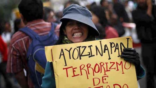 A demonstrator holds a sign alleging state terrorism during a protest against the government’s handling of the missing students in Mexico City last month.