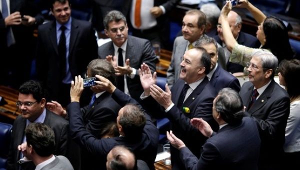 Members of Brazil's Senate react after a vote to remove President Dilma Rousseff from office in Brasilia, Brazil, May 12, 2016.