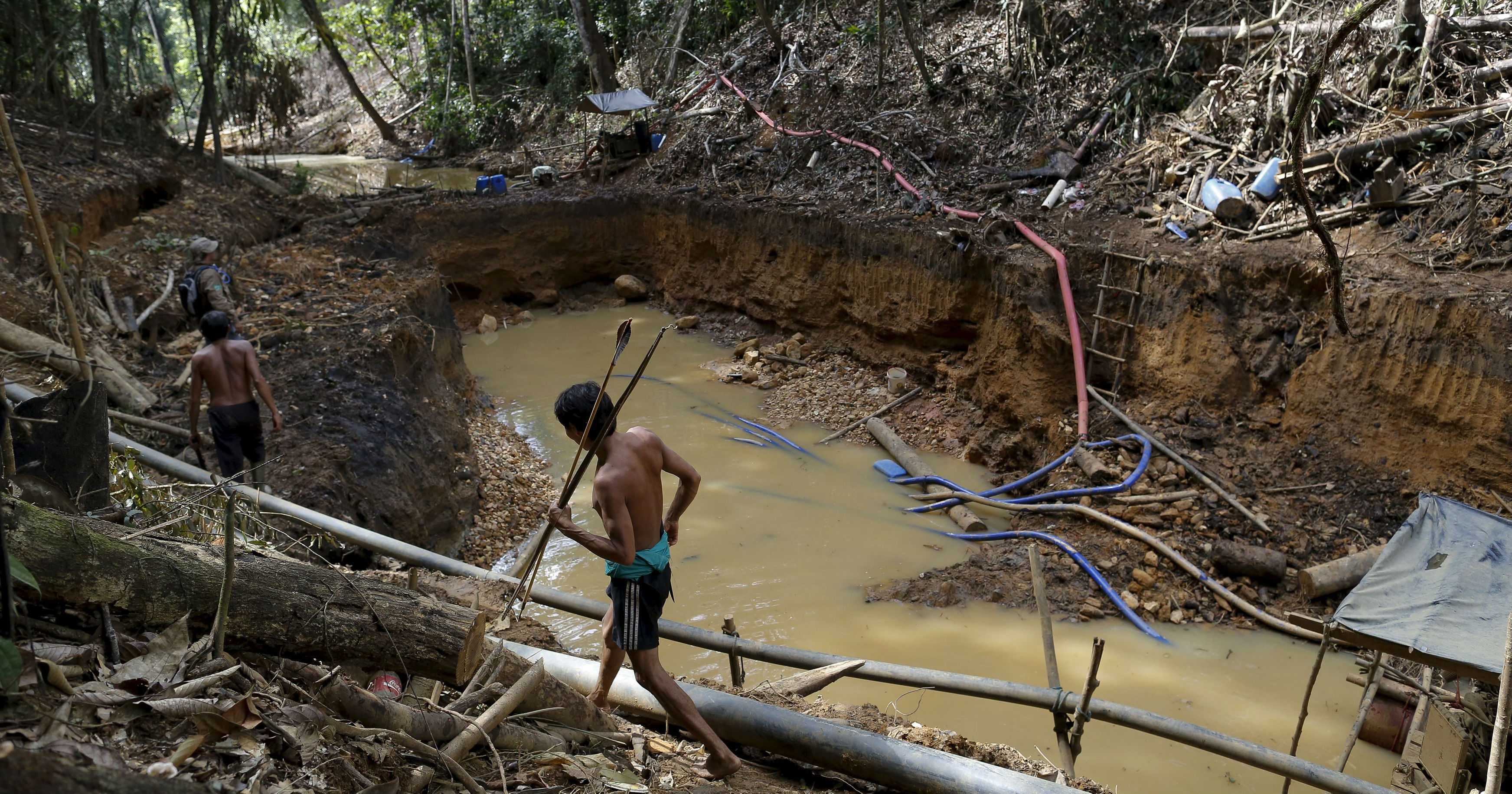 Yanomami indians follow agents of Brazil's environmental agency in an illegal gold mine in the heart of the Amazon rainforest, in Roraima state, Brazil.