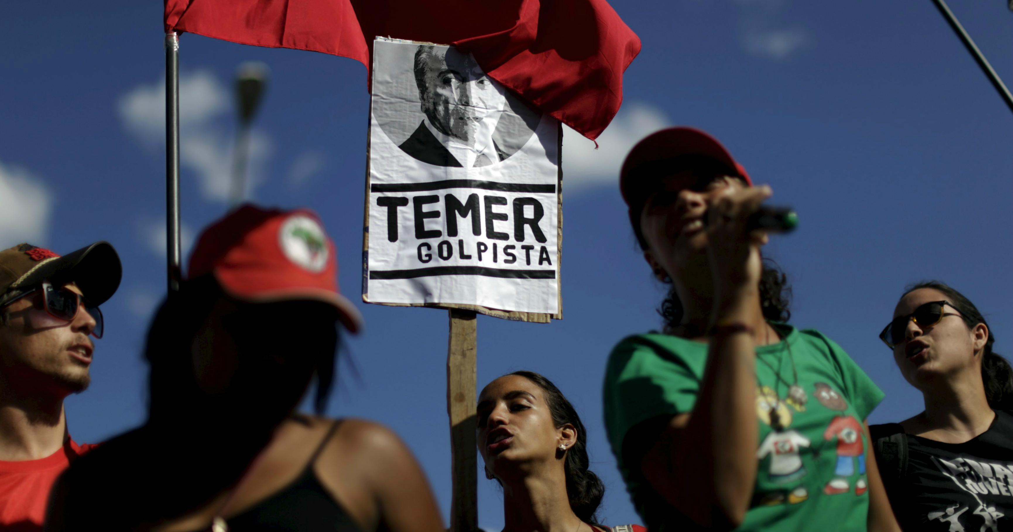 Members of social movements hold signs during a protest against Brazil's Vice President Michel Temer in front of Jaburu Palace in Brasilia, Brazil