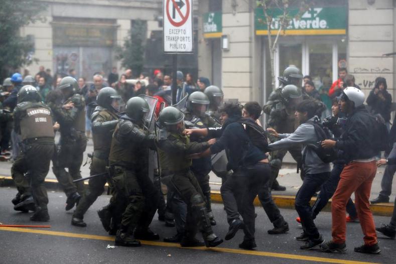 Student protesters clash with riot policemen during a demonstration to demand changes in the education system in Santiago.
