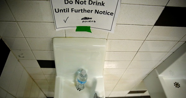 A sign is seen next to a water dispenser at North Western high school in Flint, a city struggling with the effects of lead-poisoned drinking water, in Michigan May 4, 2016.