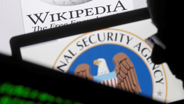 A man is seen near cyber code and the U.S. National Security Agency logo in this photo illustration taken in Sarajevo March 11, 2015