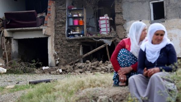 Women sit in front of a house which was damaged in an explosion on Thursday, near the Kurdish-dominated southeastern city of Diyarbakir.