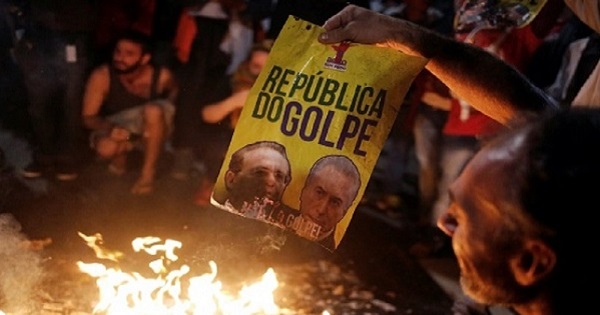Protesters in Brazil burn a poster with the images of Senate President Calheiros (L) and Brazil's senate-imposed president Temer, in Sao Paulo, May 12, 2016.