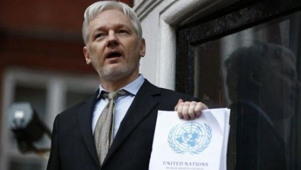 WikiLeaks founder Julian Assange holds a copy of a U.N. ruling as he makes a speech from the balcony of the Ecuadorian Embassy, in central London, Britain Feb. 5, 2016.