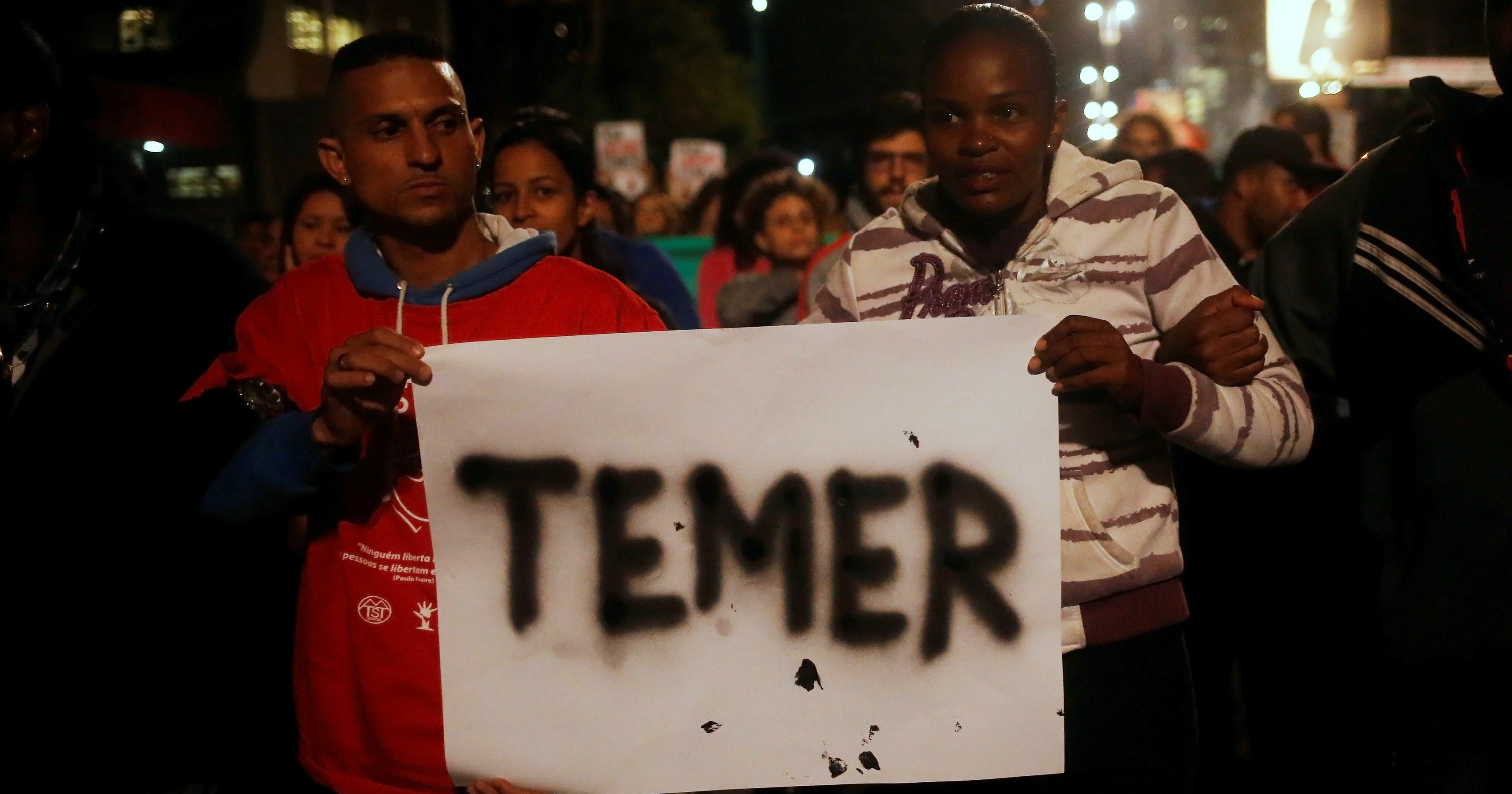 Members of Brazil's Homeless Workers' Movement hold a banner with the name of interim President Michel Temer during a protest in Sao Paulo, May 12, 2016.