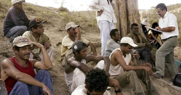 A group of Brazilian slave laborers listens to a Labor Ministry inspector (R) explain their legal rights on the Bom Jesus farm in the Amazon basin.