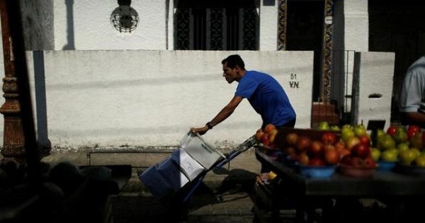 A worker pushes boxes with food at a street market in Rio de Janeiro, Brazil, May 6, 2016.