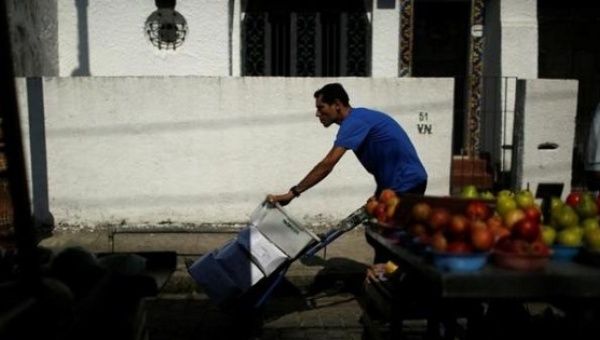 A worker pushes boxes with food at a street market in Rio de Janeiro, Brazil, May 6, 2016.