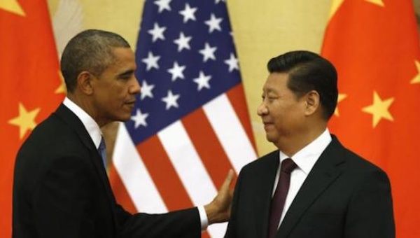 U.S. President Barack Obama pats Chinese President Xi Jinping on the shoulder at the end of their news conference in the Great Hall of the People in Beijing Nov. 12, 2014.