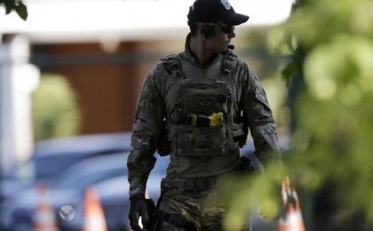 A federal police officer walks in front of the home of former house speaker Eduardo Cunha during a raid in Brasilia, Brazil, Dec. 15, 2015.