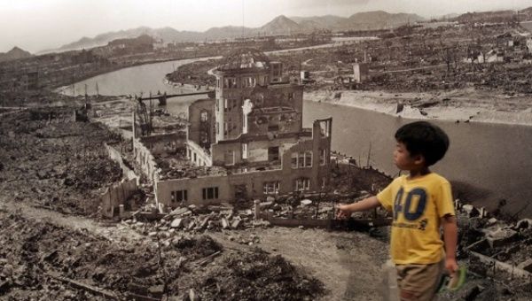 A child observes a photo of the destruction left behind by the U.S. nuclear bombing of Hiroshima. 