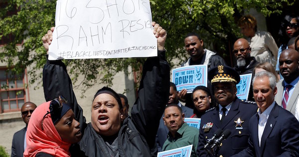 A protester demonstrates against the shooting of Laquan McDonald in front of Chicago Mayor Rahm Emanuel and police superintendent Eddie Johnson during a news conference earlier this month.