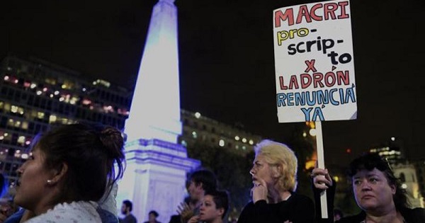 A woman holds a sign reading 