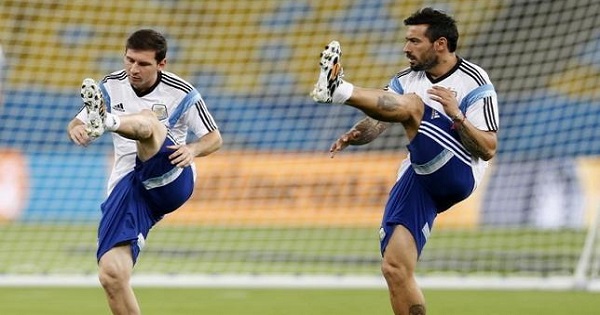 Argentine national soccer team players Lionel Messi (L) and Ezequiel Lavezzi exercise during a training session for the 2014 World Cup at the Maracana stadium in Rio de Janeiro, June 14, 2014.
