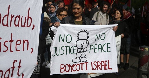 An activist holds a sign calling for the boycott of Israel.