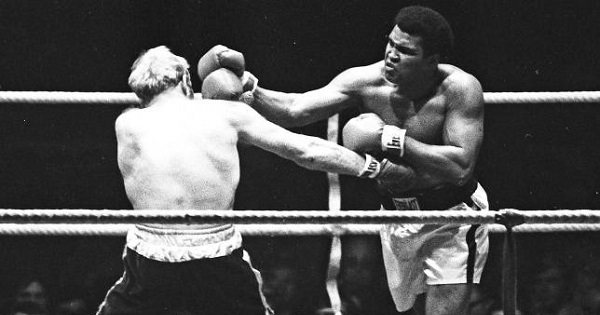 Muhammad Ali (L) punches Richard Dunn while fighting for the WBC & WBA Heavyweight
