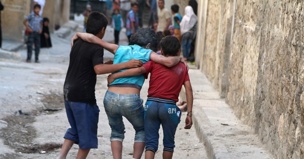 Boys help their injured friend after an airstrike on Aleppo's rebel held al-Fardous district.