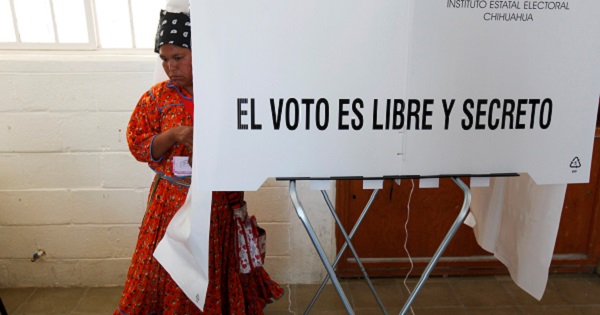 An Indigenous woman leaves a booth to cast her ballot during regional elections in Ciudad Juarez, Mexico, June 5, 2016.