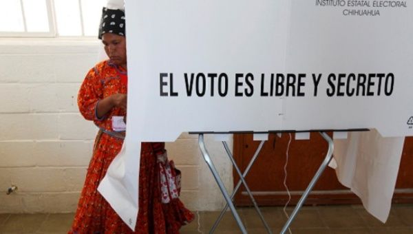 An Indigenous woman leaves a booth to cast her ballot during regional elections in Ciudad Juarez, Mexico, June 5, 2016. 
