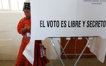 An Indigenous woman leaves a booth to cast her ballot during regional elections in Ciudad Juarez, Mexico, June 5, 2016. 
