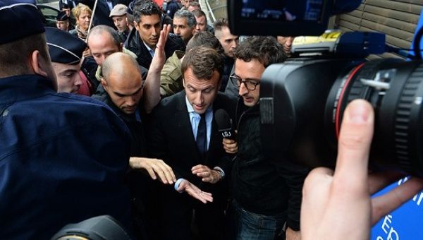 Macron (C) speaks to reporters after being pelted with eggs by protesters
