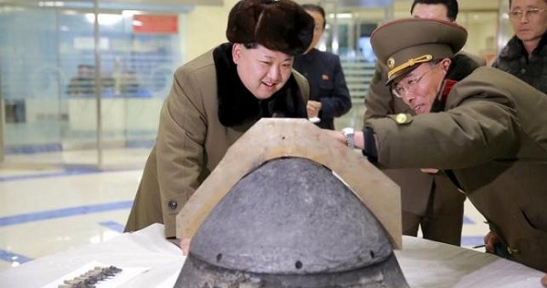North Korean leader Kim Jong Un looks at a rocket warhead tip after a simulated test of atmospheric re-entry of a ballistic missile, at an unidentified location in this undated file photo.