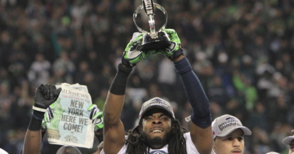 The Seattle Seahawk's Richard Sherman holding up the National Football Conference championship trophy, 2013.
